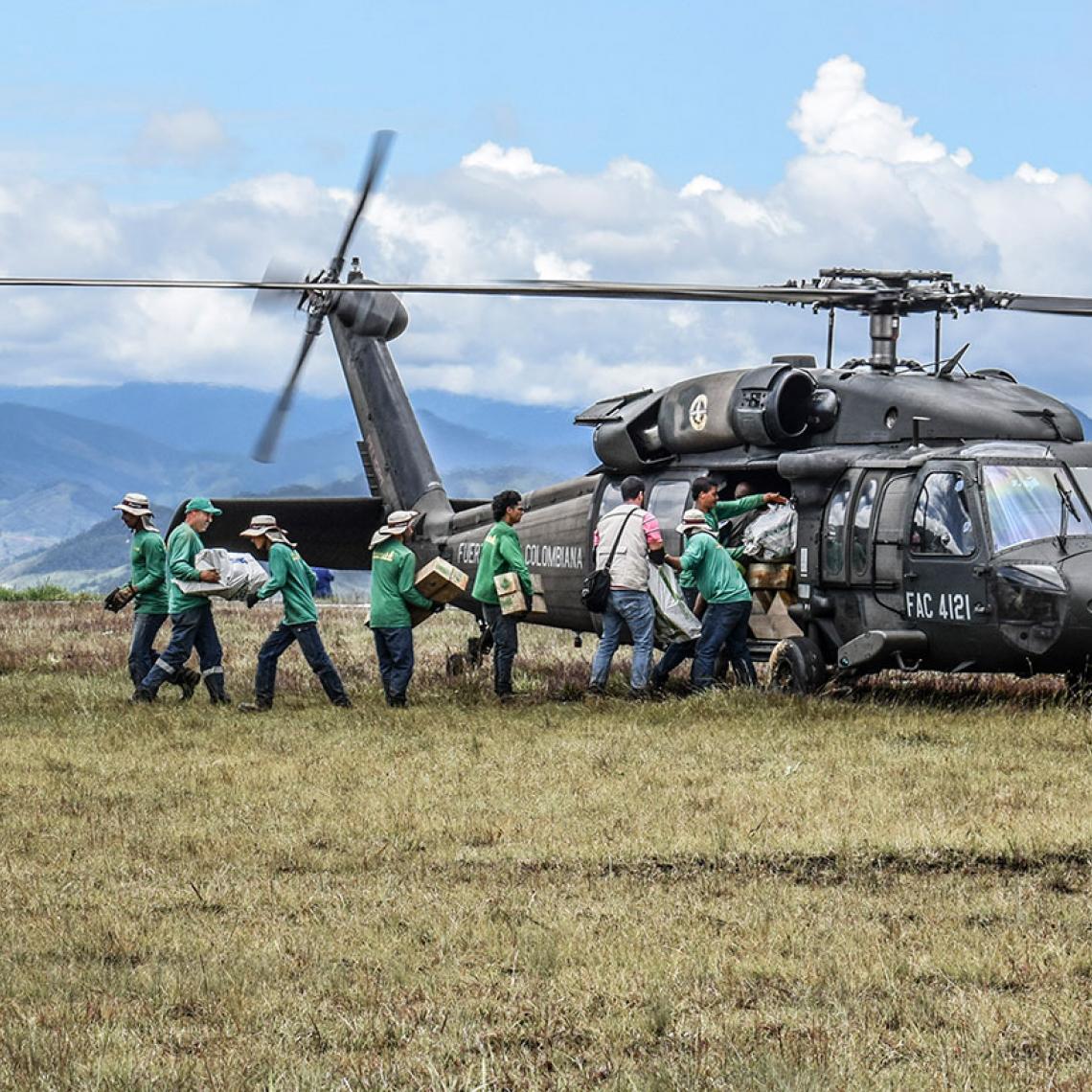 Hombres de la Fuerza Aérea cargando un helicóptero con ayuda humanitaria