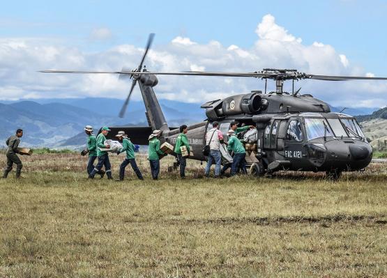 Hombres de la Fuerza Aérea cargando un helicóptero con ayuda humanitaria